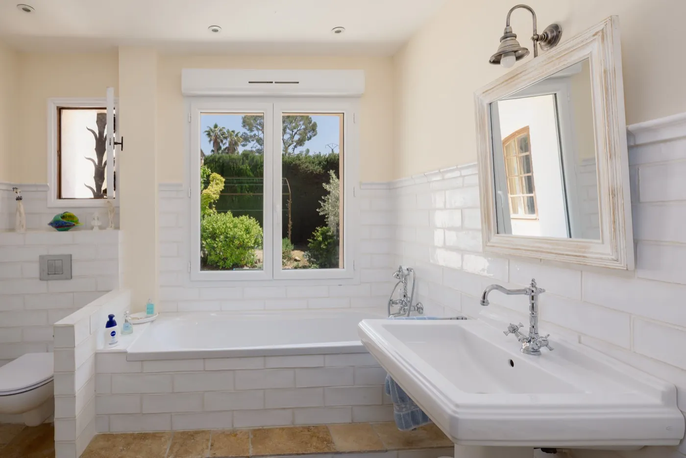 Helles Badezimmer mit Badewanne und Gartenblick