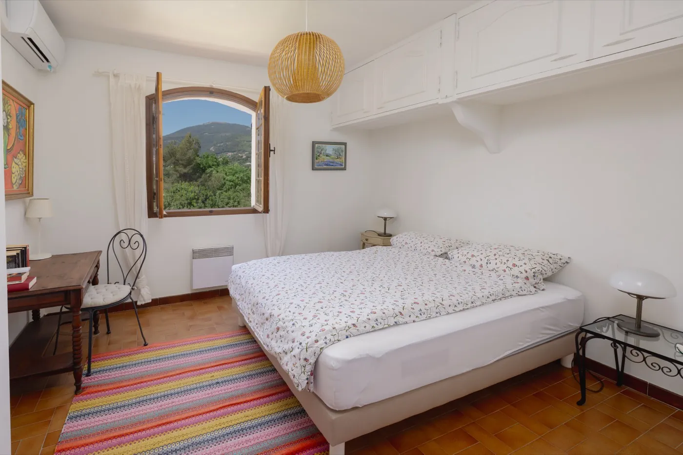 Schlafzimmer mit buntem Teppich und Bergblick