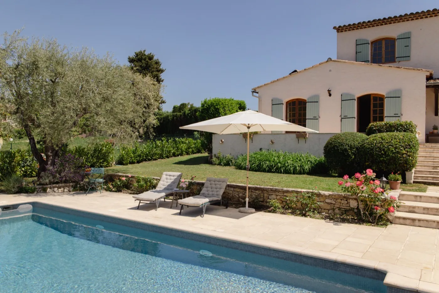Außenansicht der Villa mit grünen Fensterläden und Pool